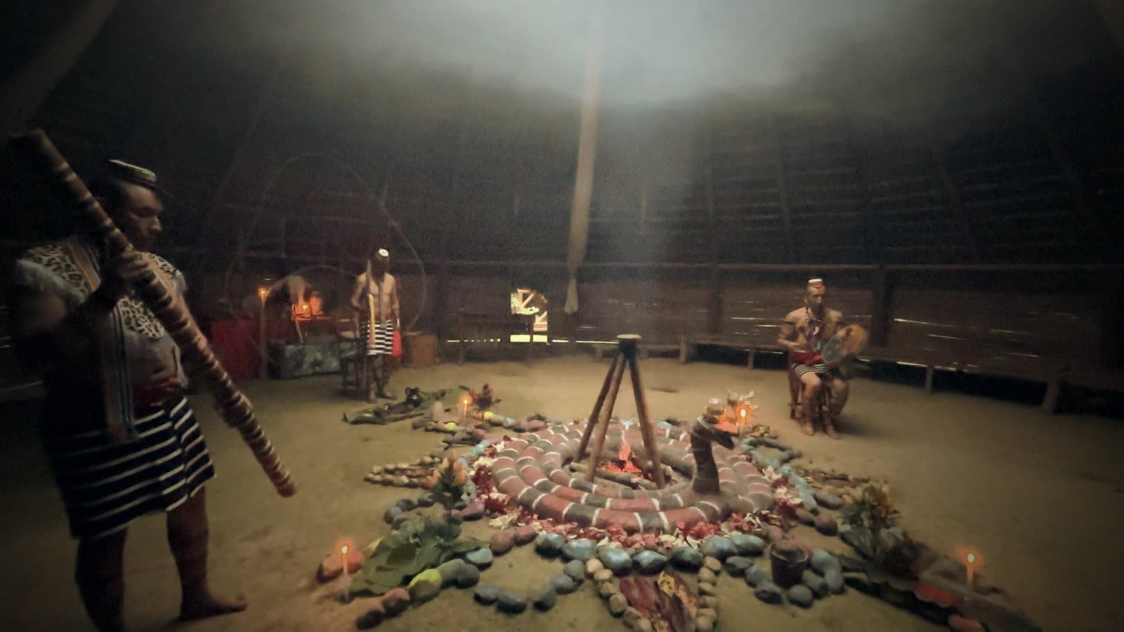 Ceremonia dentro de la maloka, con piedras de colores y fuego al centro